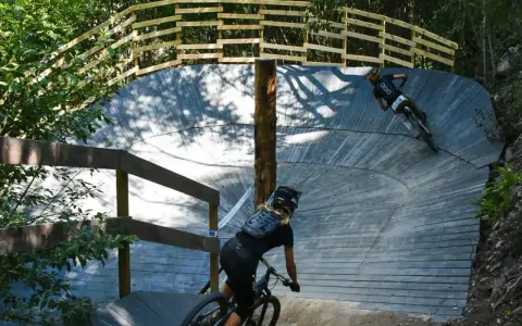 Två cyklister på en träbana i skogen, en spännande mtb-upplevelse nära Stockholm.
