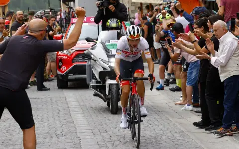 Giulio Ciccone fährt auf seinem Rennrad durch eine Gasse, umgeben von jubelnden Zuschauern und Motorrädern.