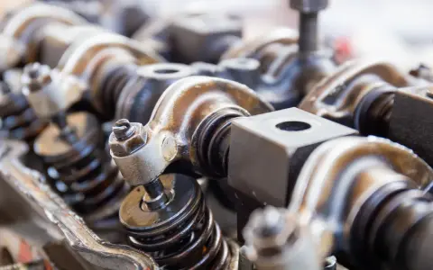 Close-up of engine valve train components, hinting at a camshaft sensor replacement.