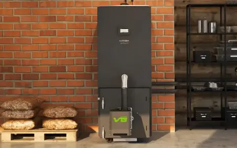 Nowoczesny piec na pellet z zielonym logo VG. Obok paleta z workami pelletu. Dofinansowanie na piec na pellet pomoże obniżyć koszty ogrzewania.