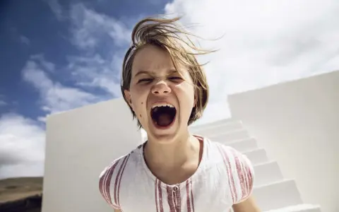 Kind schreit laut, Haare wehen im Wind. Ein Moment, der an einen affektive Dysregulation test erinnert.