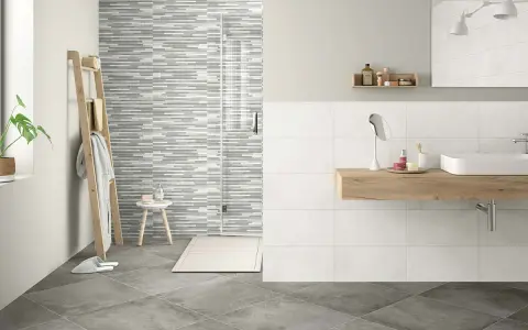 Baño moderno con ducha de azulejos grises y blancos. Aprende como limpiar azulejos baño para mantenerlo impecable.