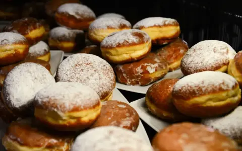 Puszyste pączki z piekarnika, niektóre oprószone cukrem pudrem, inne błyszczące od lukru. Idealne na tłusty czwartek!