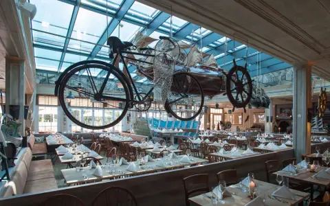 Einzigartiges Ambiente im Bell Rock Restaurant. Die Speisekarte wartet in einem Raum mit Deckeninstallationen, die an Schiffe und Fahrräder erinnern.