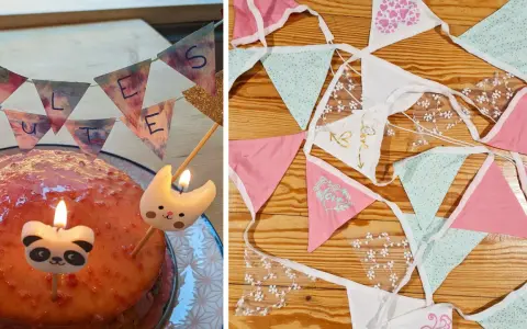 Geburtstagskuchen mit Kerzen und einer selbstgebastelten Papierkette. Daneben liegen weitere bunte Wimpelketten zum Basteln.