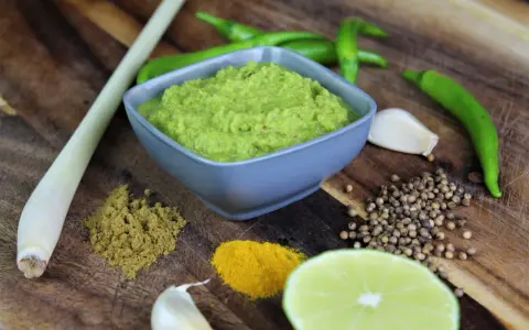 Frische Zutaten für **Currypaste selber machen**: grüne Chilis, Zitronengras, Knoblauch, Koriandersamen, Kurkuma, Kreuzkümmel und Limette.