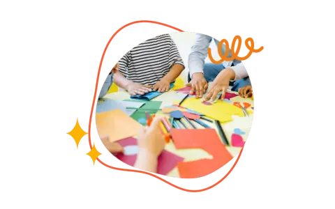 Kreative Hände falten Papier und malen bunte Kreise. Kinder und Erwachsene basteln gemeinsam.