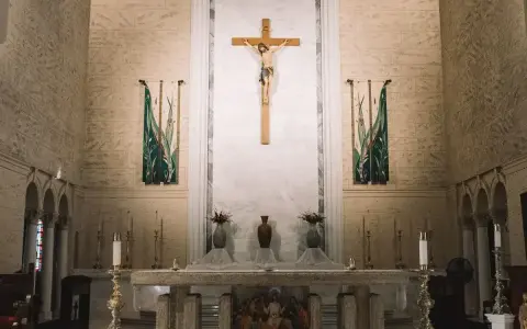 Ołtarz w kościele z krzyżem i świecami. W tle wiszą ozdobne banery. Szukasz imiona do bierzmowania męskie?
