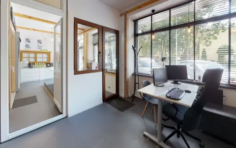 Wnętrze biura z biurkiem, komputerami i oknami. Widok na recepcję z ekspozycją okien.