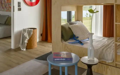 Un lit superposé dortoir maternelle en bois, avec des coussins douillets et un avion bleu pour l'aventure.