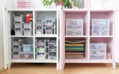 Ein aufgeräumter Bastelschrank mit vielen beschrifteten Boxen, die FIMO, Marker und Bastelmaterialien enthalten. Alles ist perfekt organisiert.