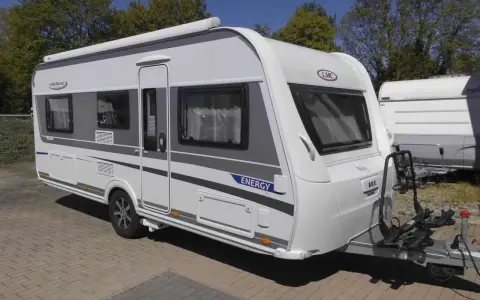Nowy lmc caravan "Energy" gotowy na wakacje. Biało-szary, z bagażnikiem na rowery.