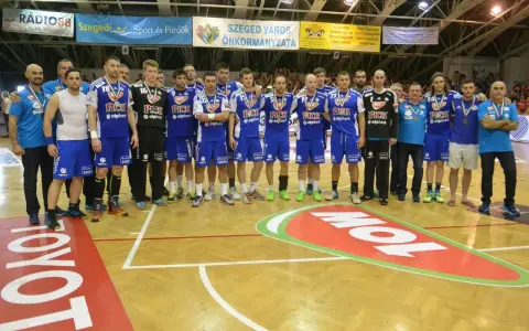 Drużyna piłkarzy ręcznych PICK Szeged w niebieskich strojach pozuje do zdjęcia po meczu.