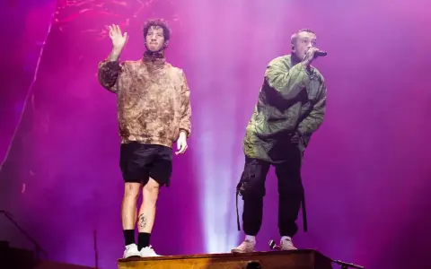 Tyler Joseph i Josh Dun z twenty one pilots na koncercie. Jeden wita publiczność, drugi śpiewa.