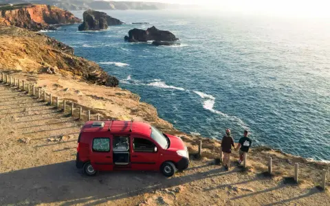 Para z kamperem na klifie w Portugalii, podziwiająca ocean. Niezapomniana podróż kamperem po Portugalii.