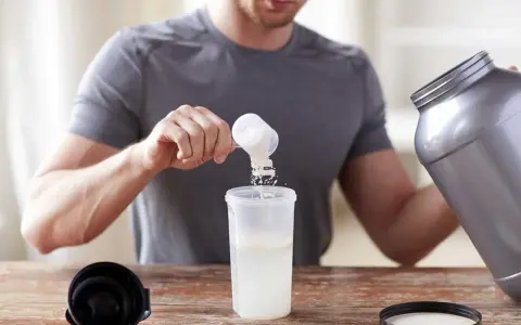 Hombre preparando un batido. Sabe cuándo tomar BCAA para optimizar su entrenamiento.