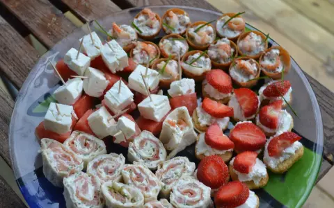 Enkla snittar till många: laxrullar, fetaost med vattenmelon, jordgubbar med grädde och räknyheter. Perfekt för festen!