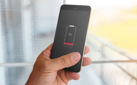 En hand håller en mobil med lågt batteri, 3%. Dags att kolla vilka appar som drar mest batteri.