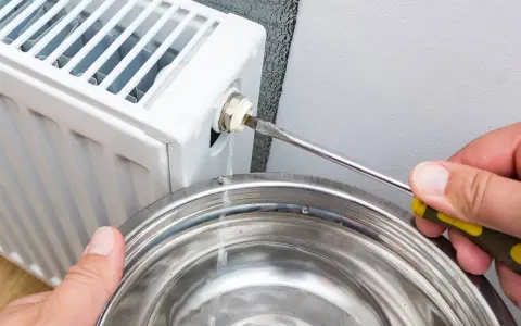 Lufta elementet för att få bort luft. Vatten rinner ner i en skål när en skruvmejsel används för att öppna ventilen.