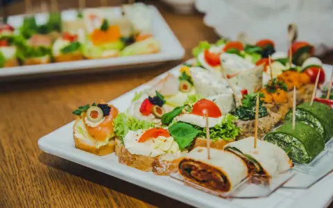 Nietypowe przekąski na imprezę: kanapeczki z łososiem, serkiem, pomidorkami, zielone roladki i tortille.