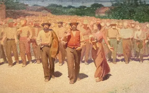 Un corteo di persone in abiti da lavoro, con un uomo in primo piano con gilet arancione. Un'immagine che evoca la vita e le tradizioni di Volpedo cosa vedere.