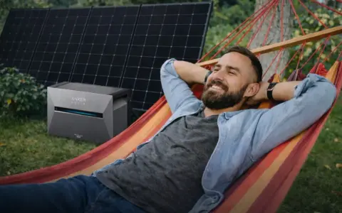 Mann entspannt in Hängematte, daneben Balkonkraftwerk Niedersachsen mit Solarmodulen.