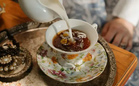 Té floral servido en una taza decorada, perfecto para celebrar los 20 años de casados. Un detalle de joyas antiguas añade elegancia.