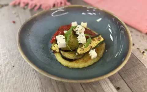 Gegrilltes Gemüse mit veganem Feta auf einem Kartoffelboden – ein köstliches Gericht für veganes Grillen.