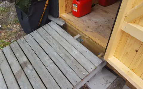 En nybyggd ramp till trappan gör det enklare att komma in i boden. En röd dunk står redo.