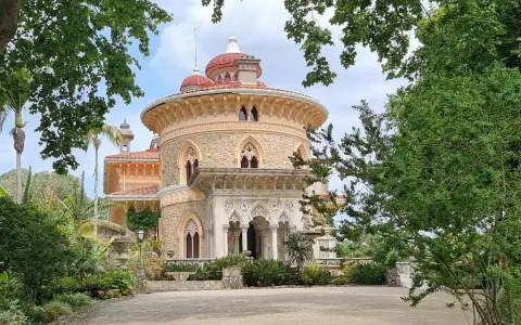The stunning Monserrate Palace in Portugal, a fairytale castle surrounded by lush greenery and exotic plants.