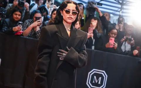 Jenna Ortega deslumbró en la Met Gala con un elegante abrigo negro y gafas de sol.