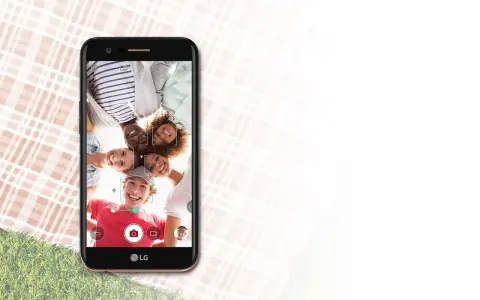 Uśmiechnięta grupa przyjaciół robi selfie telefonem LG K10 2017 Dual na pikniku.