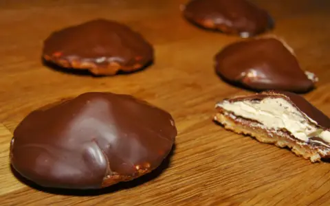Chokladbiskvier recept: Läckra chokladöverdragna biskvier med krämig fyllning på en träyta.