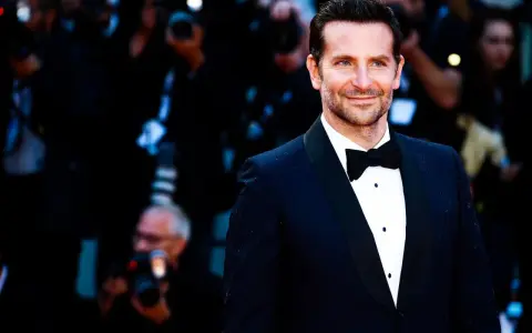 Bradley Cooper smiles, sporting a classic tuxedo. This image confirms that black tie does indeed mean tuxedo.