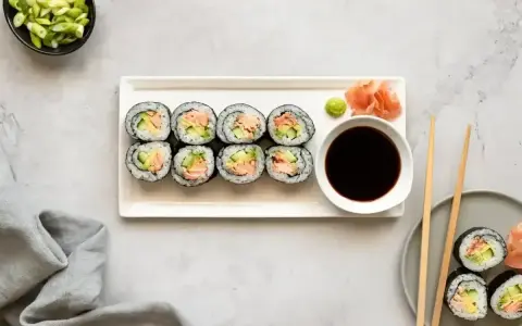 Smaczne hosomaki z łososiem i awokado, podane z sosem sojowym i wasabi.