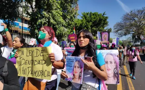 Protesters in El Salvador hold signs demanding identity rights and justice. One sign reads "Without identity law, there is no democracy.
