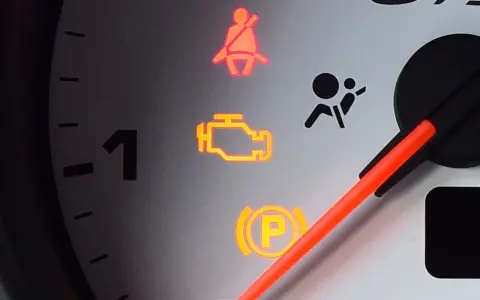 Kontrolka check engine świeci się. Czy można jeździć? Na desce rozdzielczej widać też kontrolki pasów i poduszek powietrznych.