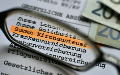 Durch eine Lupe wird die "Summe Kirchensteuer" auf einem Dokument hervorgehoben. Dies zeigt, wo Kirchensteuer anfällt.