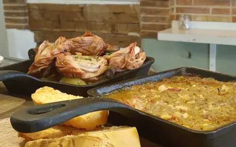 Deliciosa comida típica de Cuenca: pollo asado y un guiso con pan.