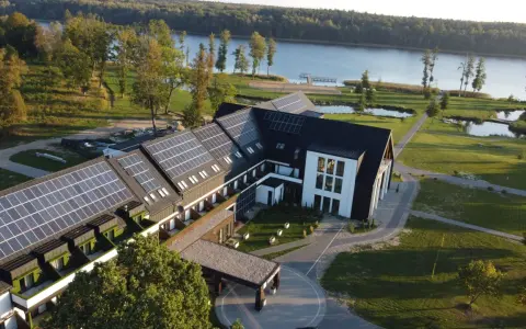 Nowoczesny hotel z panelami słonecznymi nad jeziorem, idealny na Mazury all inclusive.