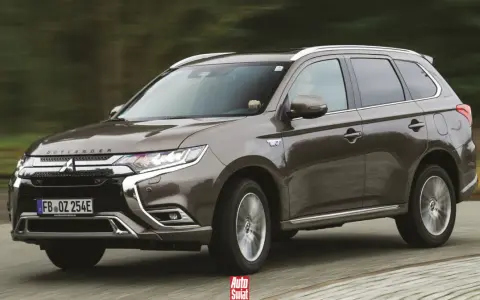Brązowy Mitsubishi Outlander PHEV jedzie po drodze.