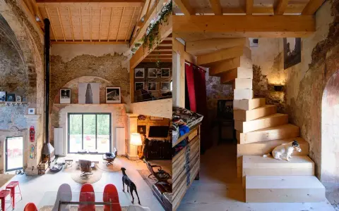 Estudio de diseño interior con escaleras de madera, perros y mobiliario ecléctico.