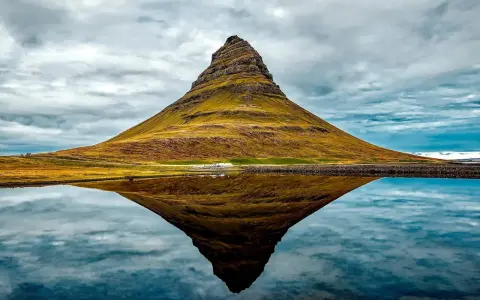Ikona Islandii, góra Kirkjufell, odbija się w spokojnej wodzie. To jedne z najpiękniejszych gór w Europie.