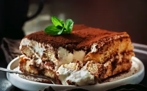 Puszyste, kremowe tiramisu, posypane kakao i udekorowane miętą. Wygląda jak najlepsze tiramisu na świecie!