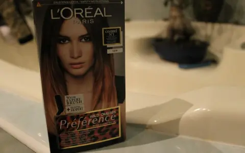 Pudełko farby L'Oréal Préférence z efektem czarne włosy ombre. Modelka na opakowaniu ma włosy w odcieniach brązu i blondu.