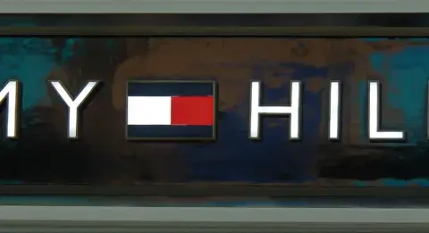 Litery TOMMY HILFIGER na tle z efektem marmuru. Poznaj, jak rozpoznać podróbkę Tommy Hilfiger, zwracając uwagę na detale logo.