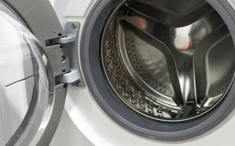 Otwarta pralka, bęben ze stali nierdzewnej. Poradnik jak podłączyć pralkę krok po kroku.