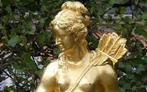 Statue dorée d'Artémis, déesse de la chasse, portant un carquois rempli de flèches sur son épaule.