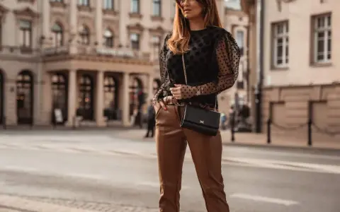 Elegancka stylizacja: czarna bluzka w kropki i brązowe skórzane spodnie. Idealne połączenie, by zadać pytanie: jaka bluzka do skórzanych spodni?