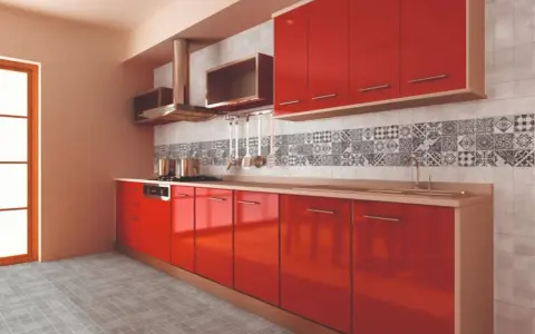 Cocina moderna con gabinetes rojos brillantes y una cenefa de azulejos con patrones geométricos en blanco y negro.